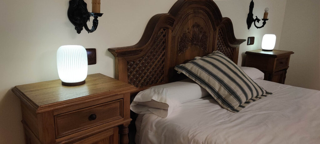 Habitación con lamparas Aura de color blanco en las mesillas.